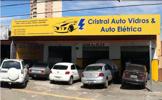 Fachada amarela da Cristal Auto Vidros & Auto Elétrica, com carros estacionados na frente